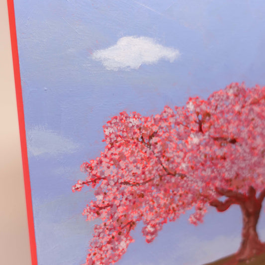 Pink-toned wooden canvas painting of flowering tree with symbolic Daruma spin inspired by nature photo