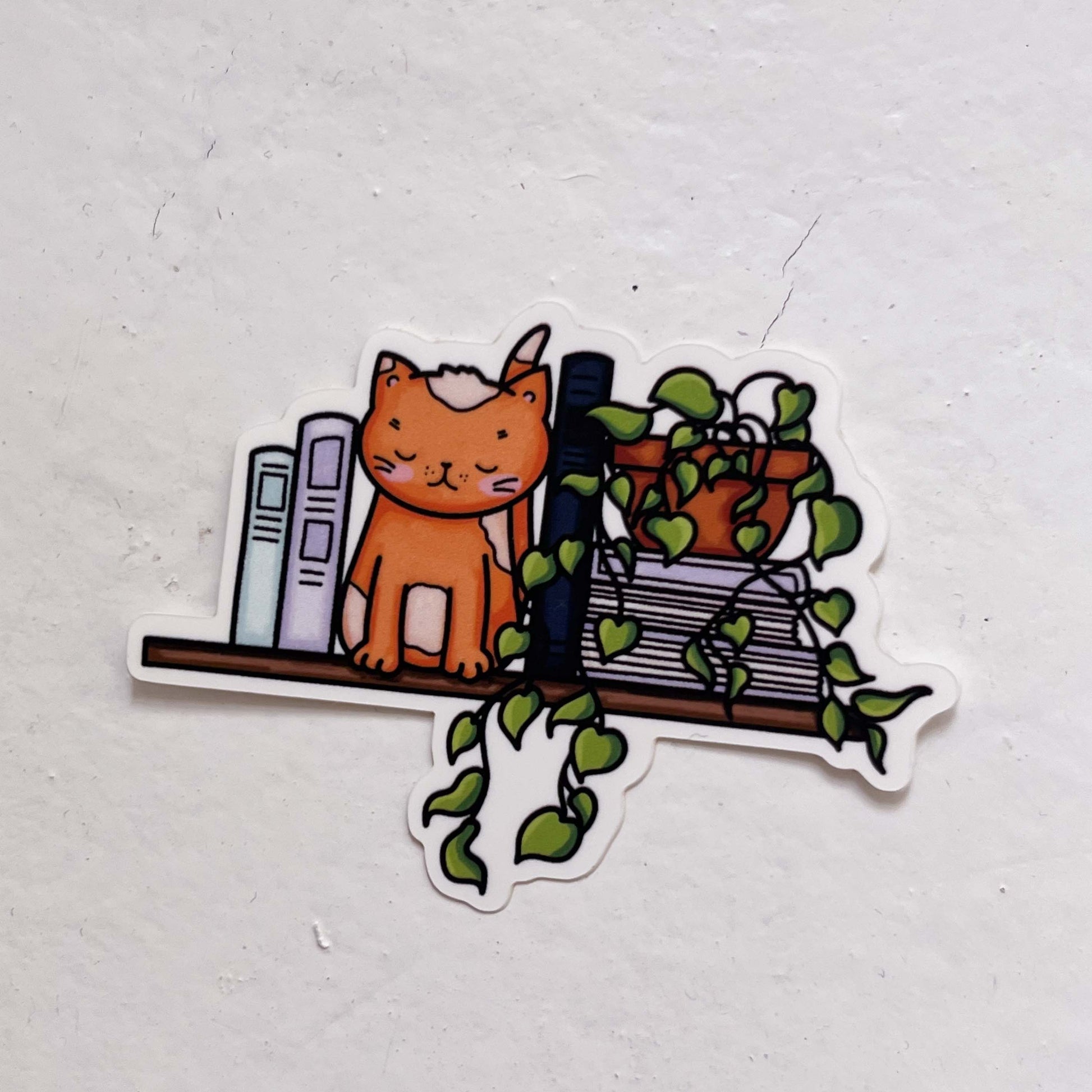 Book Nook Cat Sticker featuring a charming cat curled up in a book nook design, perfect for adding literary charm to laptops, notebooks, and water bottles
