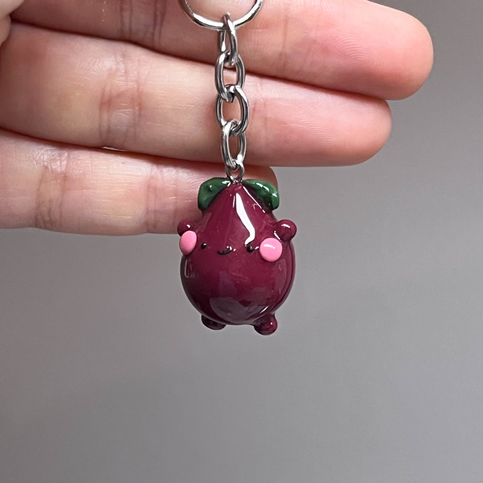 Handcrafted beetroot keychain made from polymer clay, featuring vibrant colors and a whimsical design, perfect for adding a touch of charm to your keys.