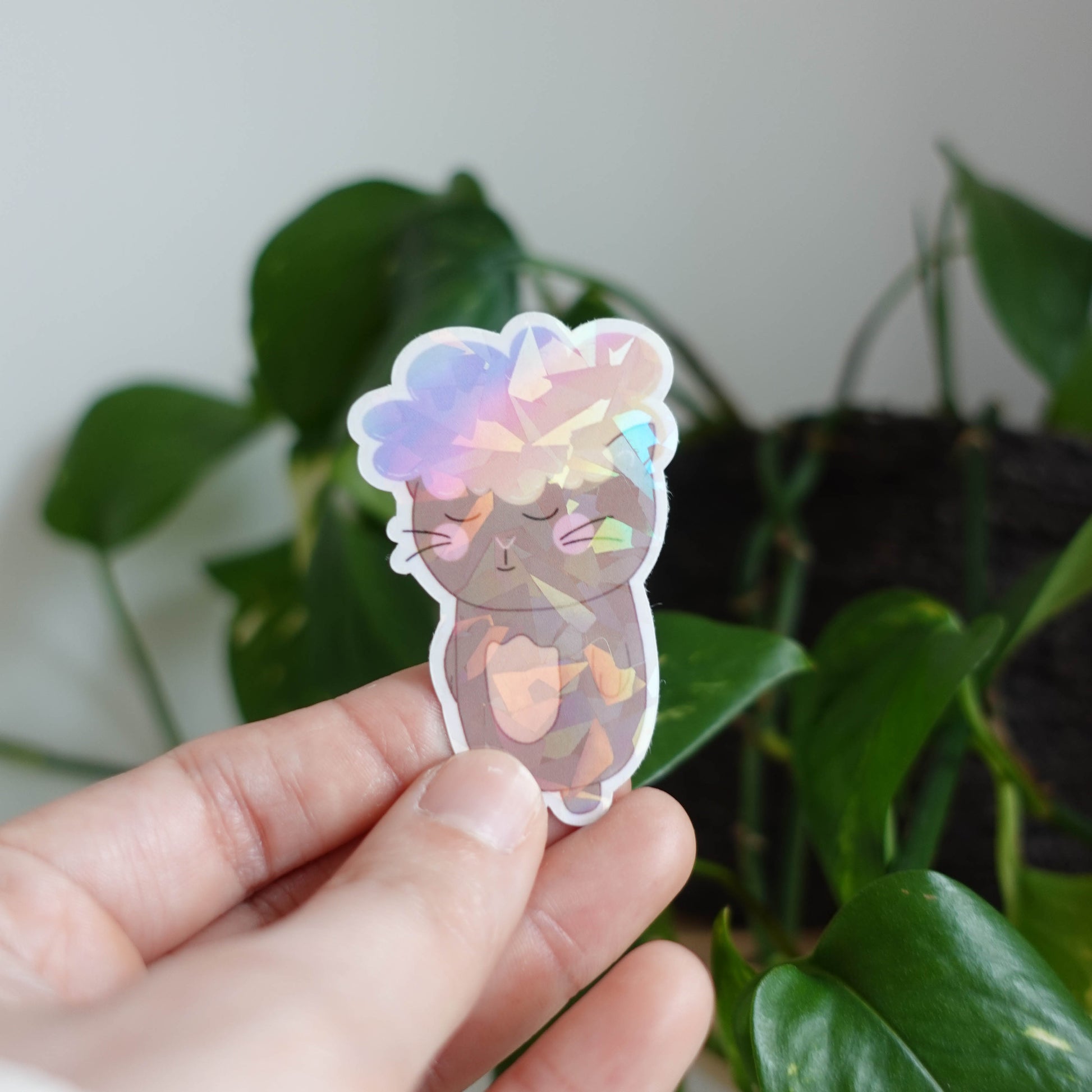 Die-cut sticker featuring an adorable cat with a fluffy cloud on its head, perfect for adding whimsy to laptops, notebooks, and water bottles.