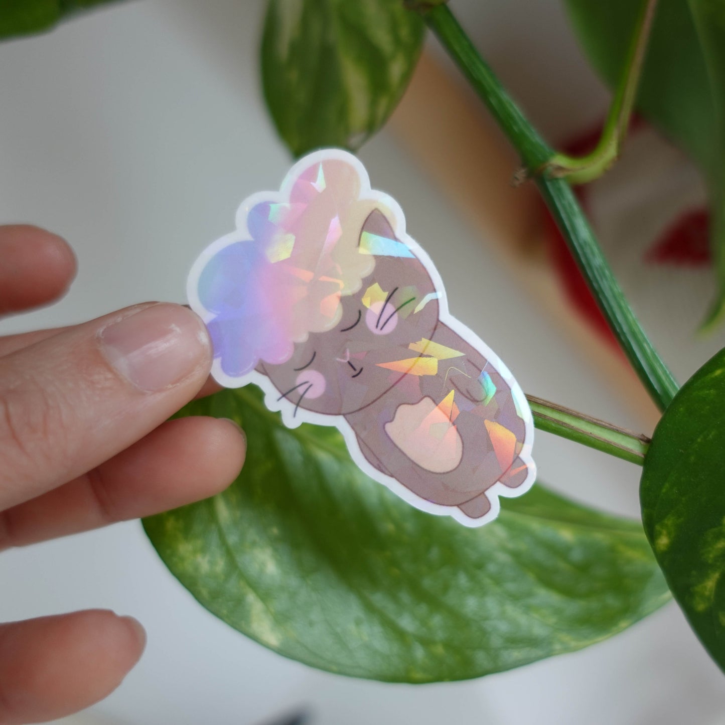 Die-cut sticker featuring an adorable cat with a fluffy cloud on its head, perfect for adding whimsy to laptops, notebooks, and water bottles.