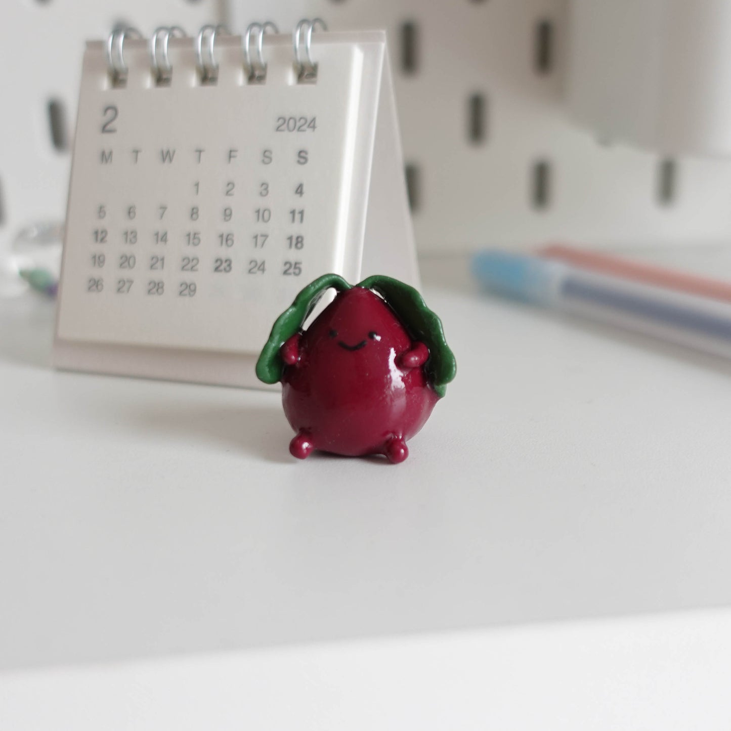 Handcrafted beetroot desk friend made from polymer clay, featuring vibrant colors and a charming design, perfect for adding whimsy to your workspace.