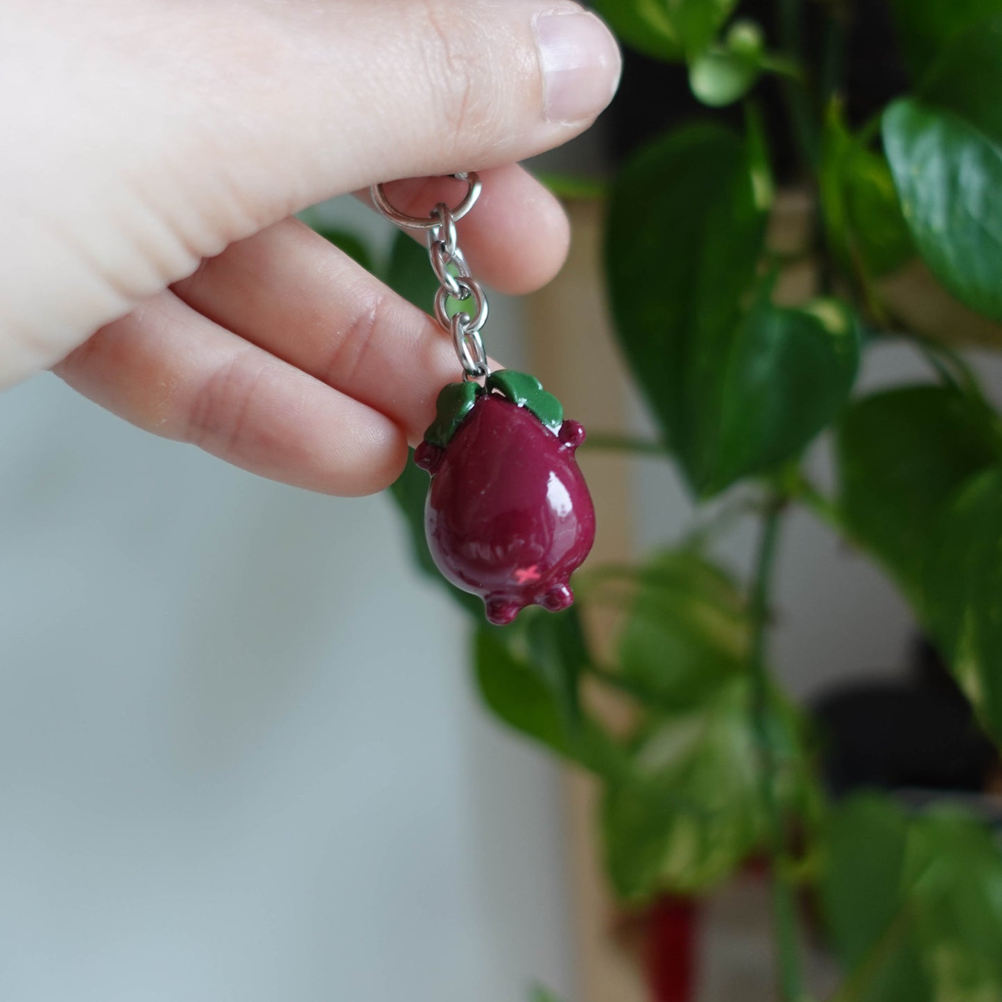 Handcrafted beetroot keychain made from polymer clay, featuring vibrant colors and a whimsical design, perfect for adding a touch of charm to your keys.