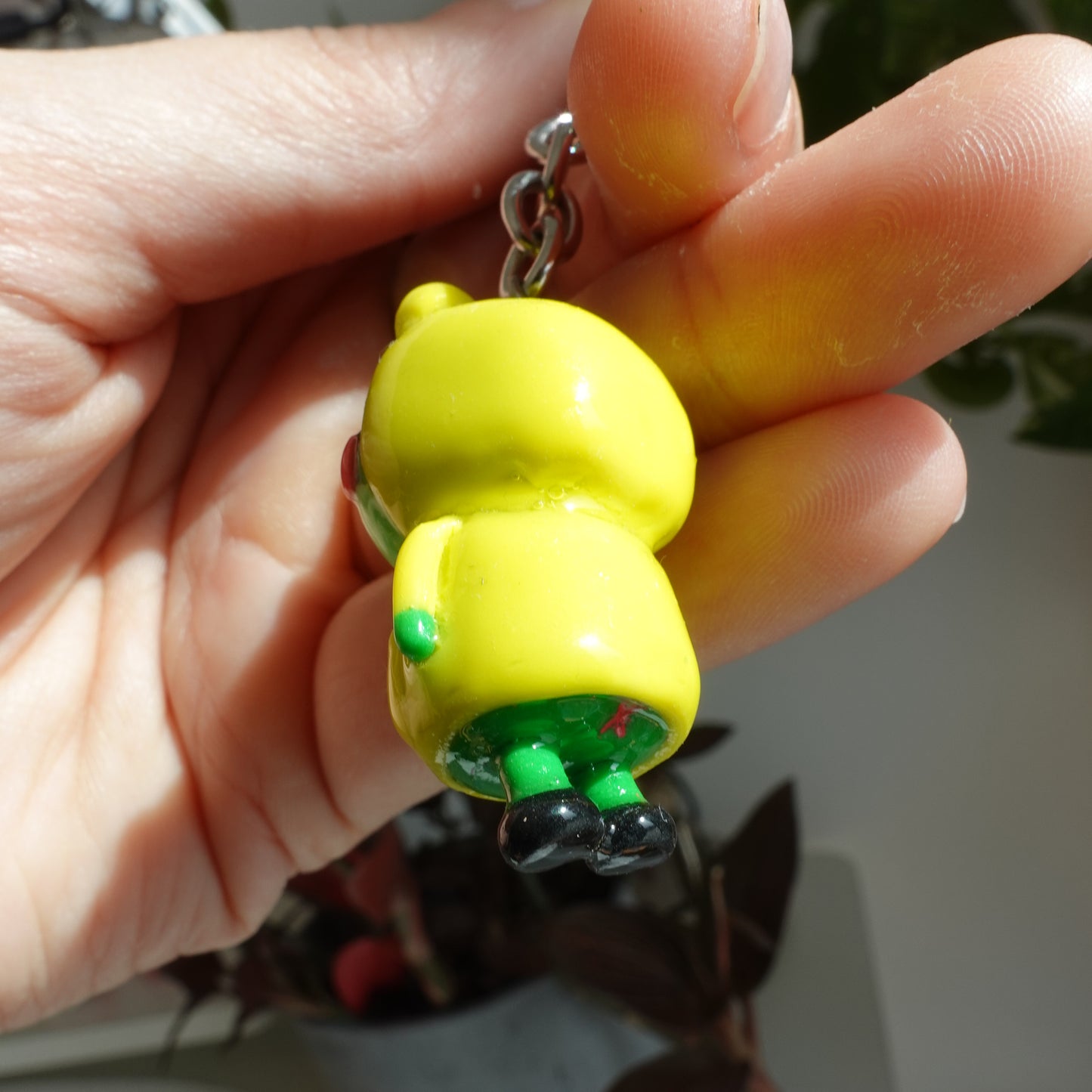 A cute frog keychain wearing a yellow raincoat and boots, adding charm to your accessories.