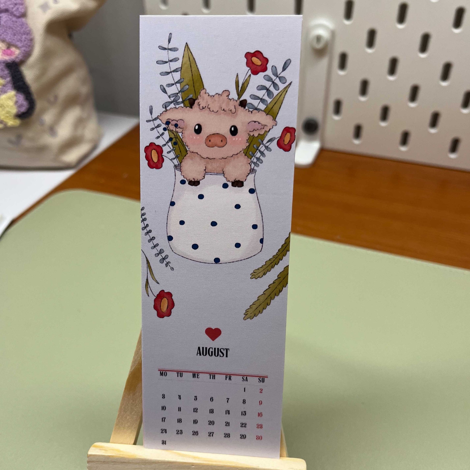 Compact 2026 bookmark-style calendar with cute seasonal artwork and mini easel stand.