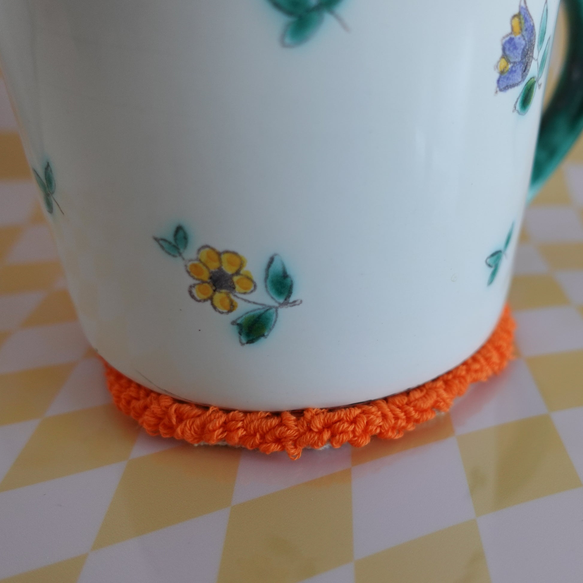 Punch needle mug rug in use, holding a mug and adding a decorative touch to a table.