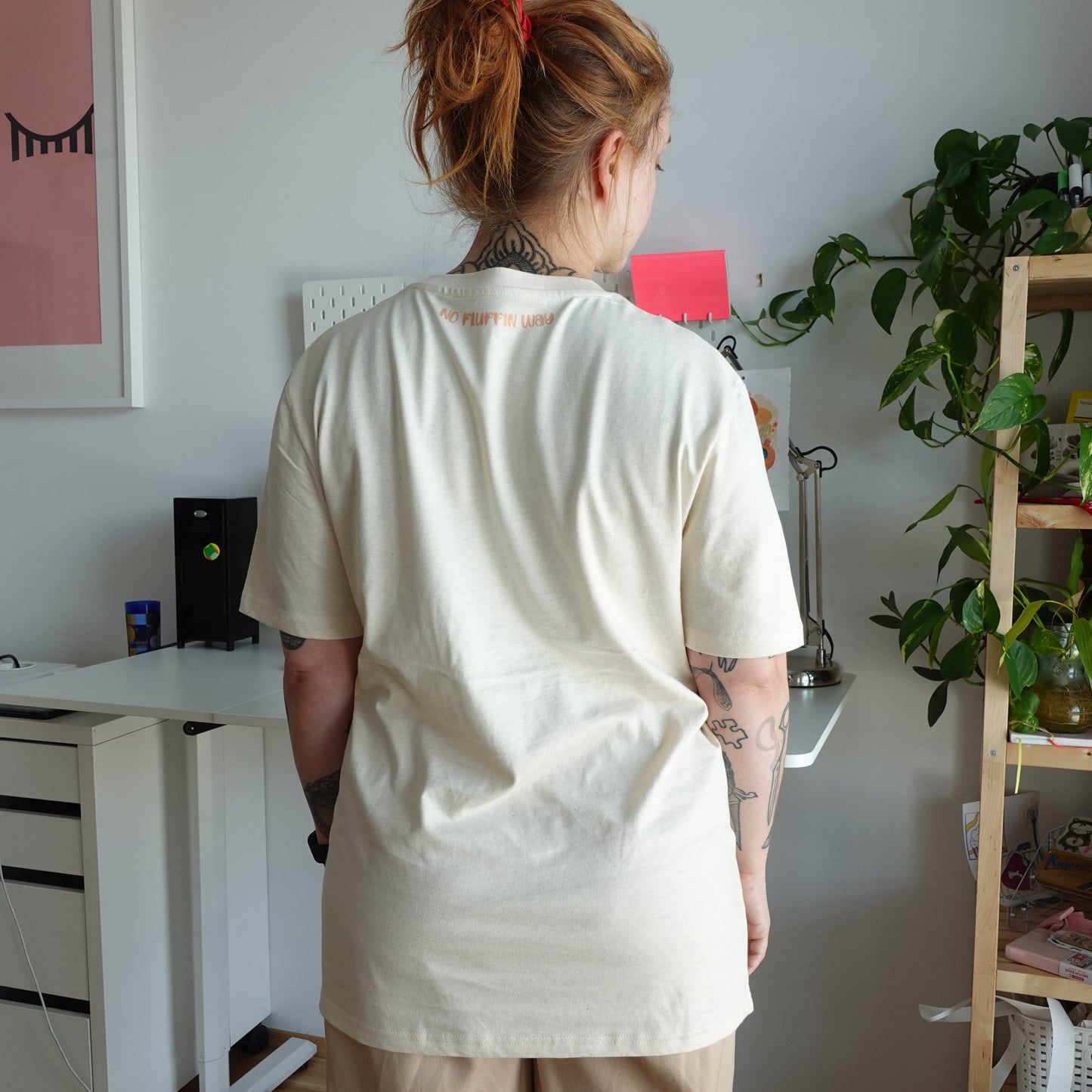 Back view of the Fluff Club punch needle t-shirt in natural raw color, showing the unique print at the neckline.