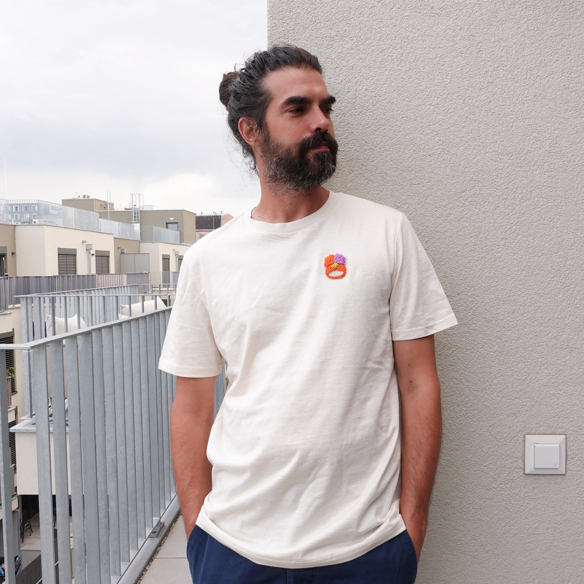 Front view of the Fluff Club punch needle t-shirt in natural raw color, featuring a handmade punch needle detail on the chest.