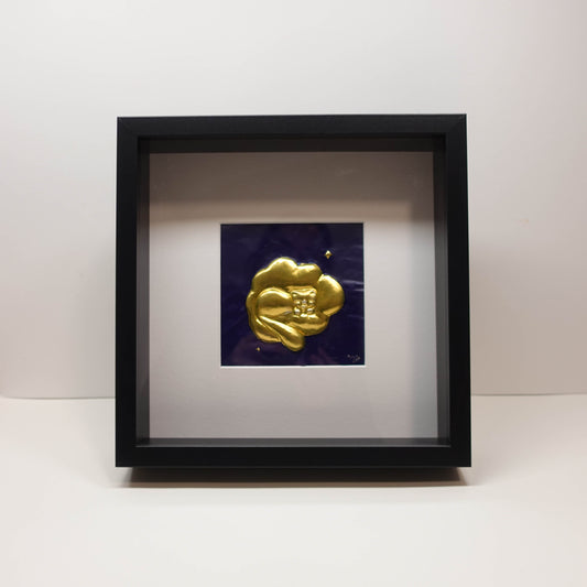 Brass 3D sculpture of a sleeping cat resting on clouds, set against a painted blue background in a recessed frame, 25 × 25 cm.