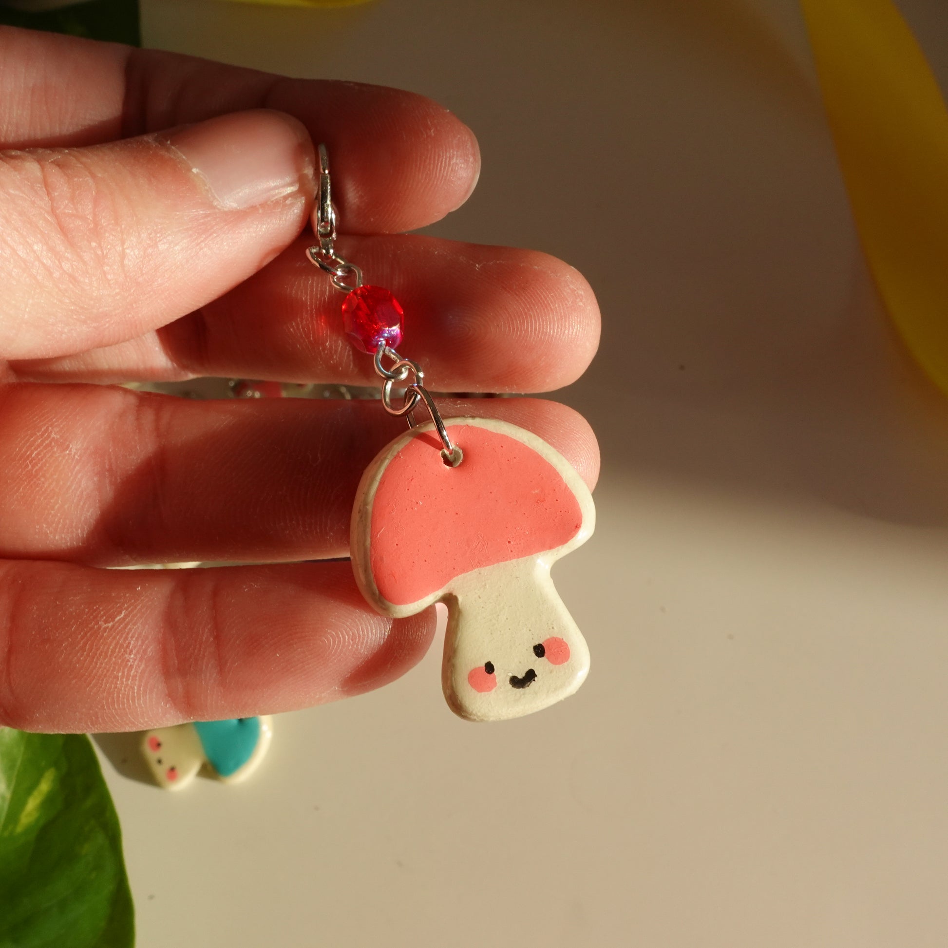 mushroom lucky charm keychain in pink with a red bead for extra added sparkle. clay charm resined to make them durable. perfect new years gift or present for the holidays to any kawaii lover and mushroom lover