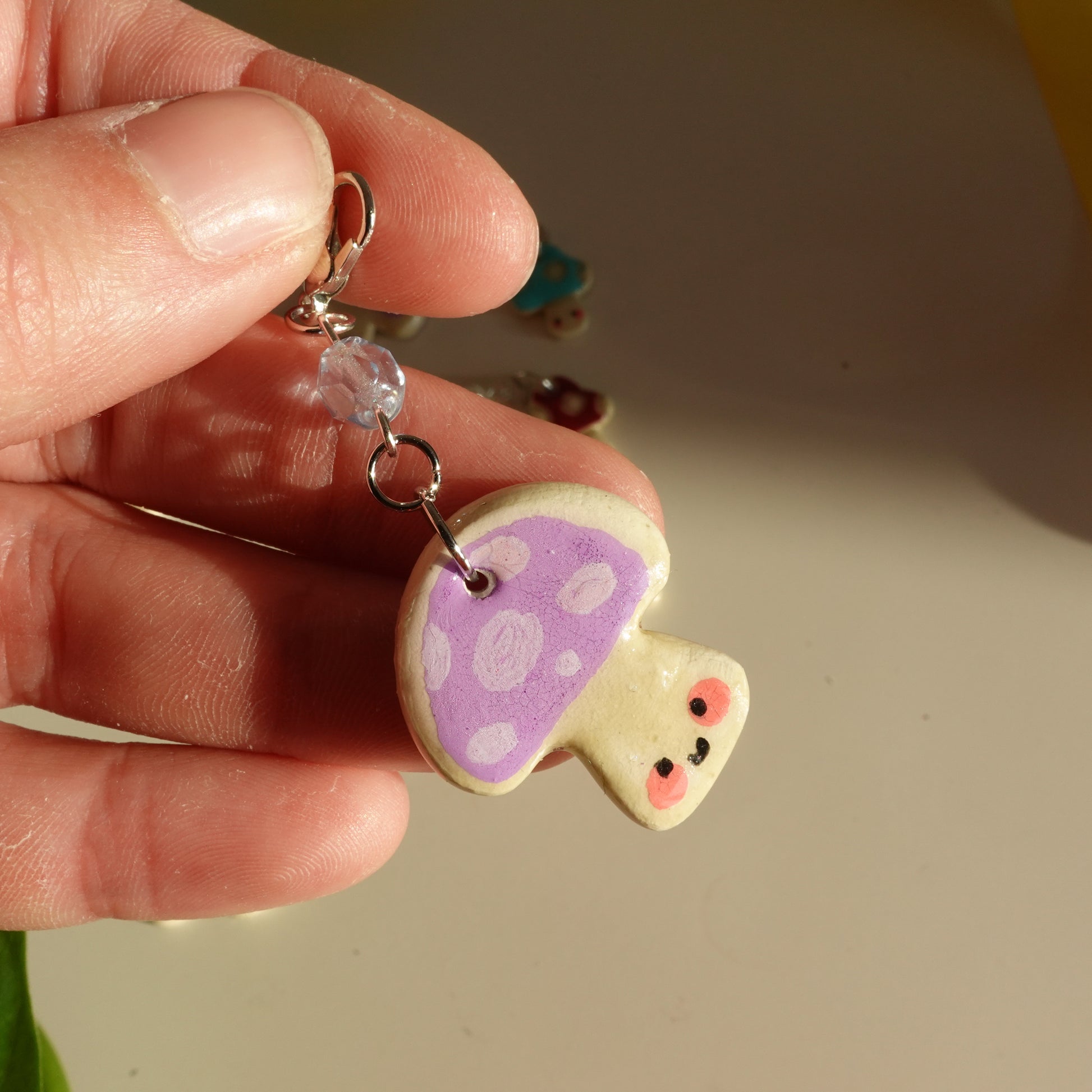 mushroom lucky charm keychain in lilac with dots and a red bead for extra added sparkle. clay charm resined to make them durable. perfect new years gift or present for the holidays to any kawaii lover and mushroom lover