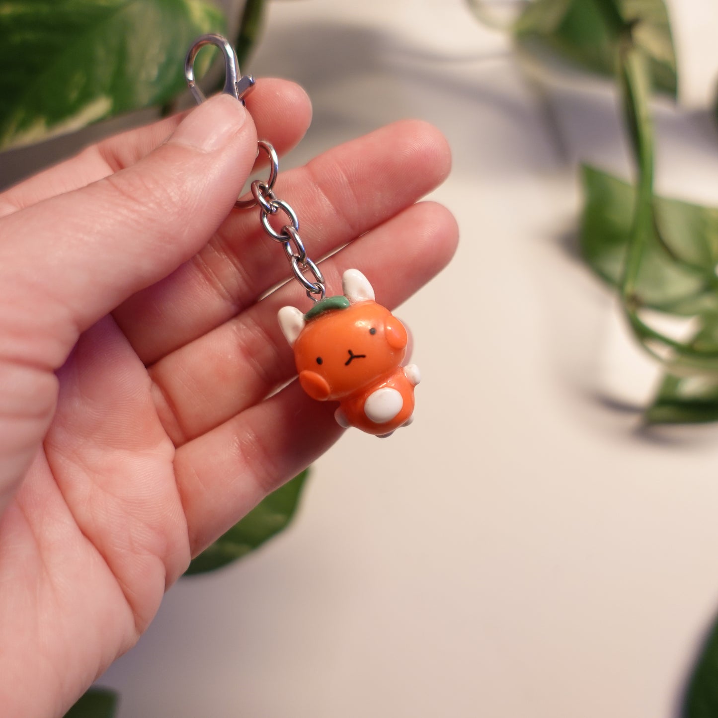 tangerine bunny keychain out of polymer clay and uv resin for durability. an all orange kawaii bunny creature to hang onto your purse, keys or bag or gift for your friends and family