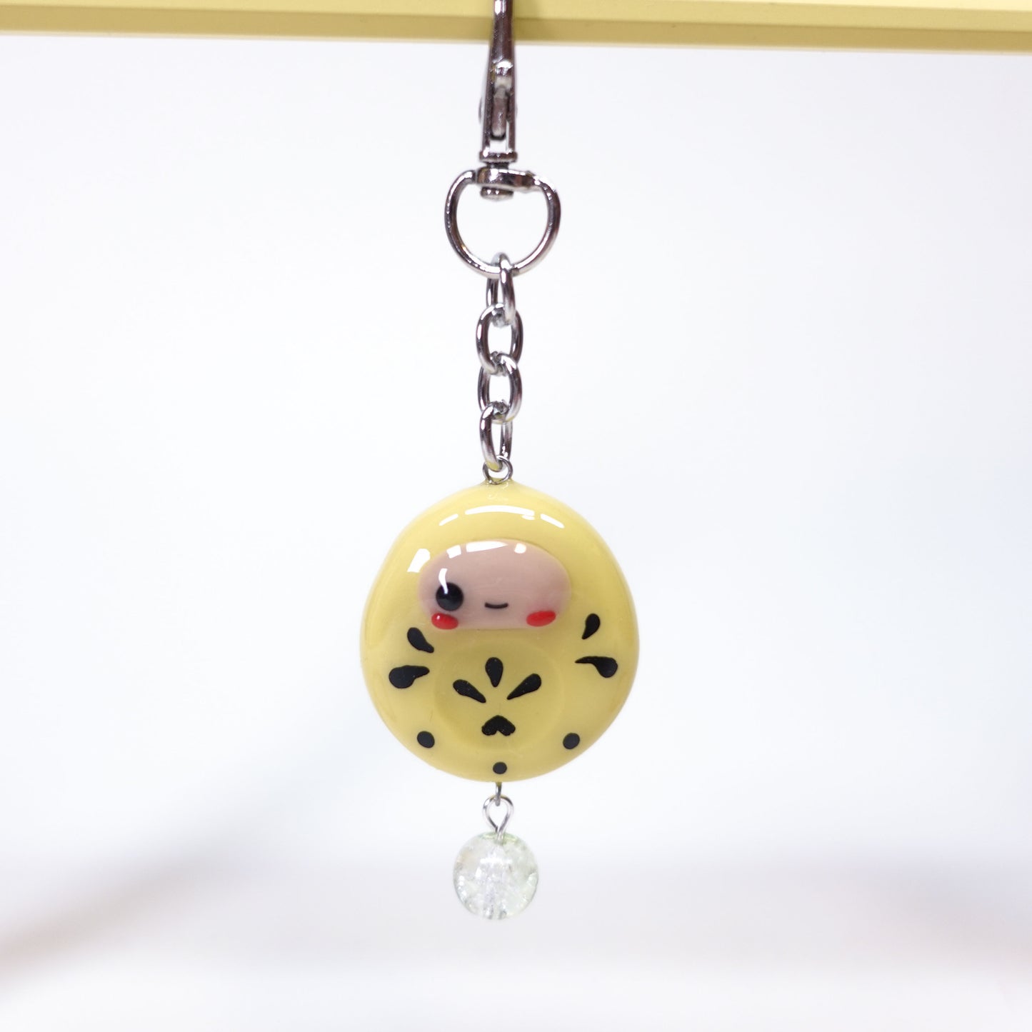 Cute Daruma lucky charm keychain with smooth thumb stone surface