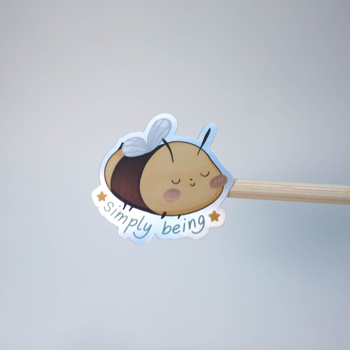 Pastel illustrated “Simply Being” vinyl sticker with soft spring colors and playful hand-drawn typography, perfect for laptops, journals, and planners.