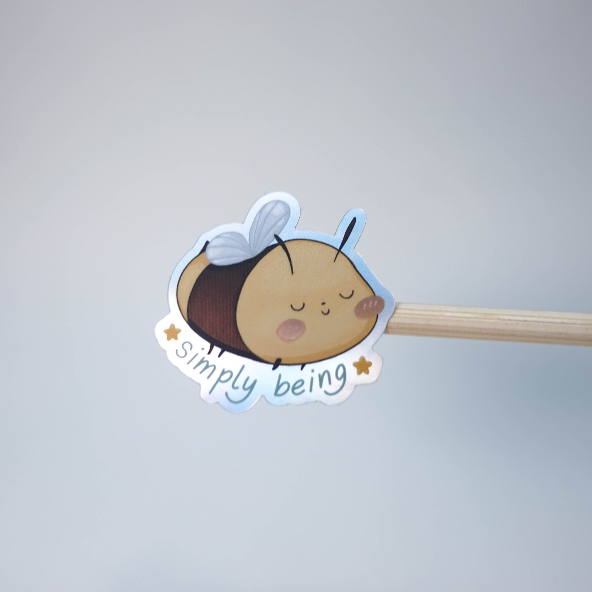 Pastel illustrated “Simply Being” vinyl sticker with soft spring colors and playful hand-drawn typography, perfect for laptops, journals, and planners.