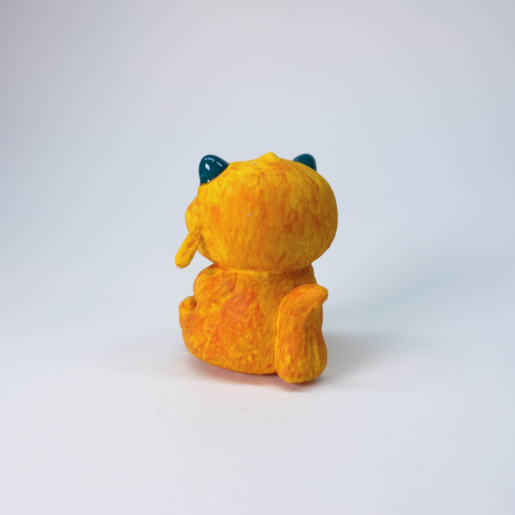 Pear Gremlin collectible resin sculpture with orange fur, glossy horns, slight side-eye, hand-painted matte finish, single limited edition piece.