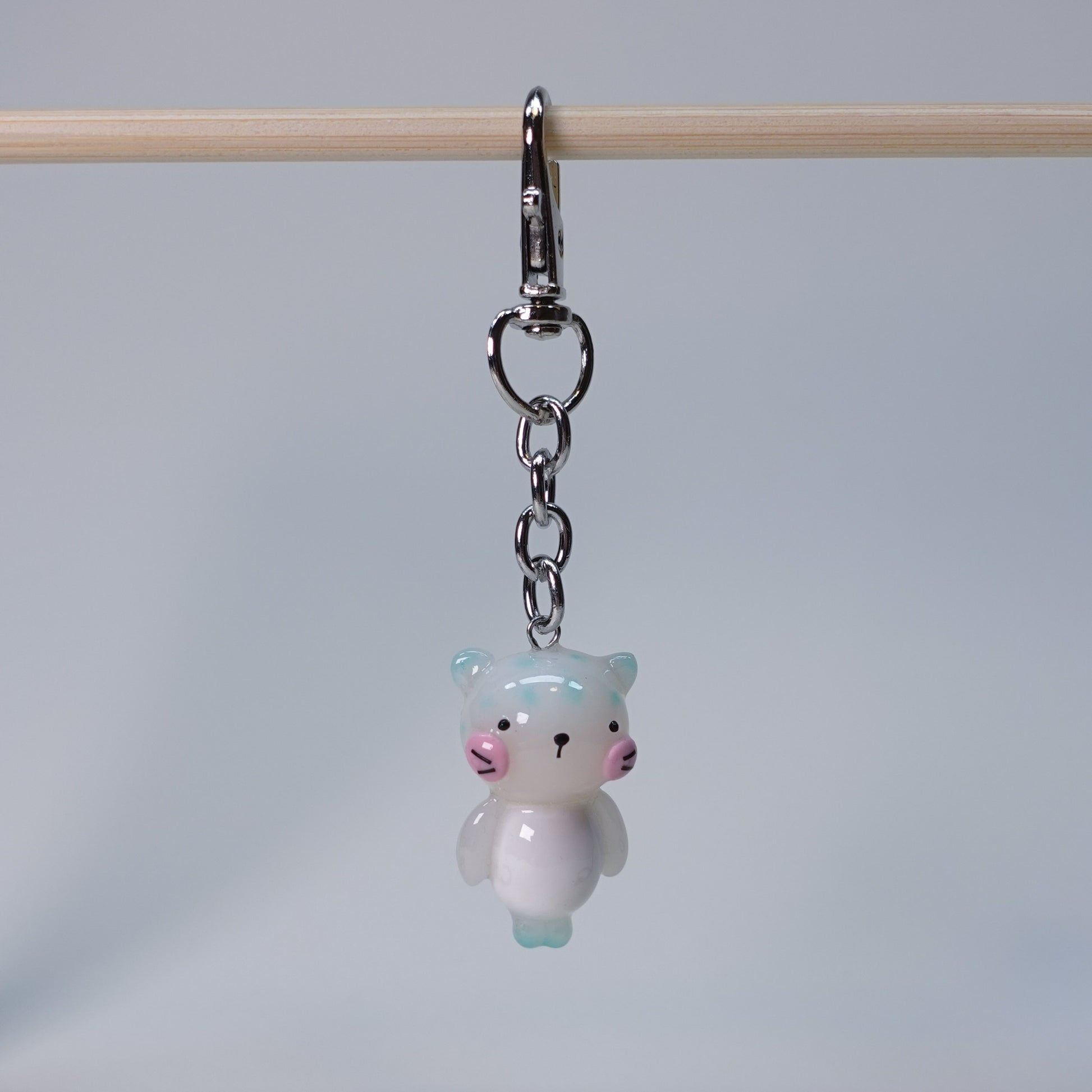 Handcrafted teal pastel cat keychain with smooth finish and playful small cat design, limited edition handmade accessory for keys or bags.
