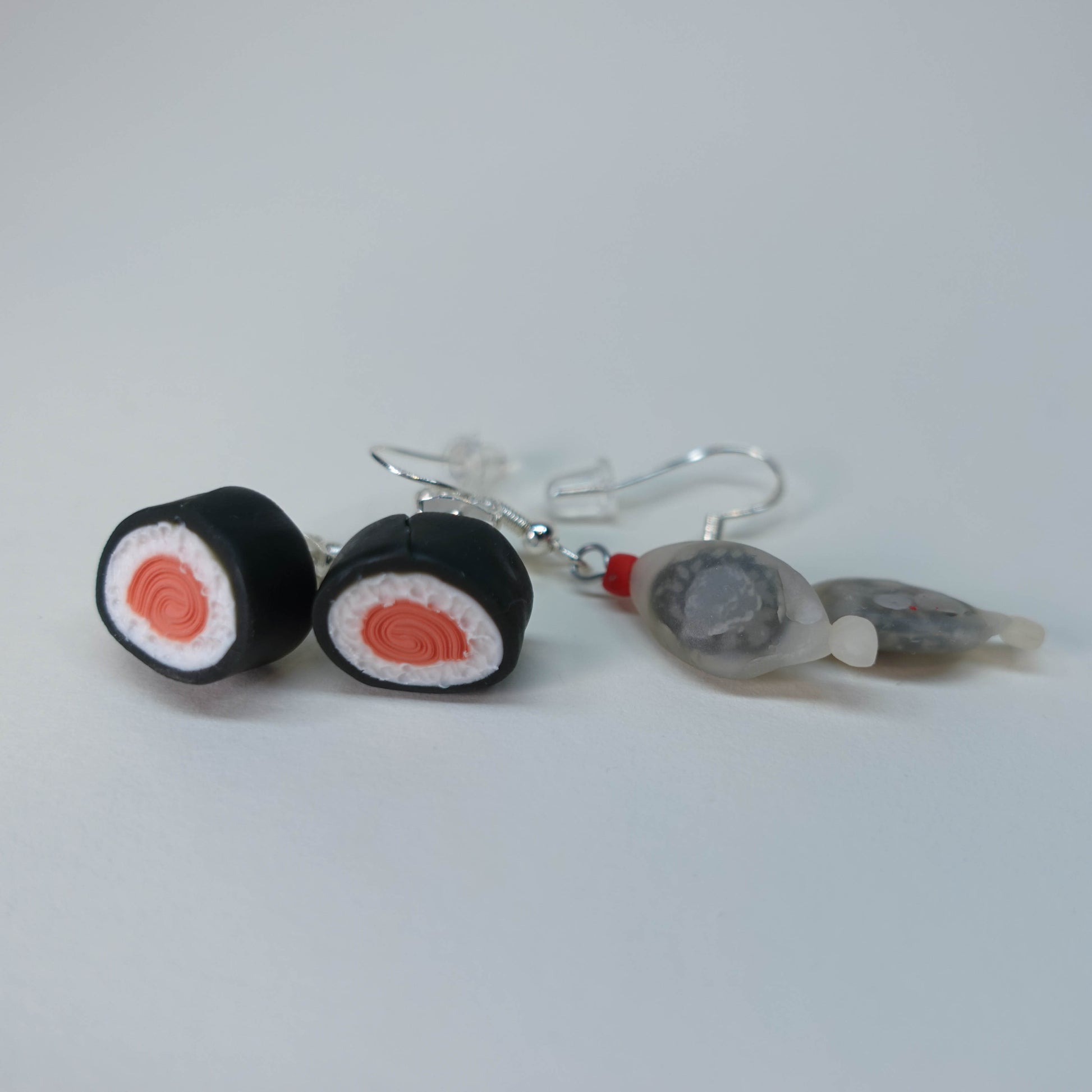 Handmade fish-shaped soy bottle earrings with matching salmon maki roll stud earrings, pastel sushi-themed set, limited edition, 4 sets available, playful accessory for daily wear.