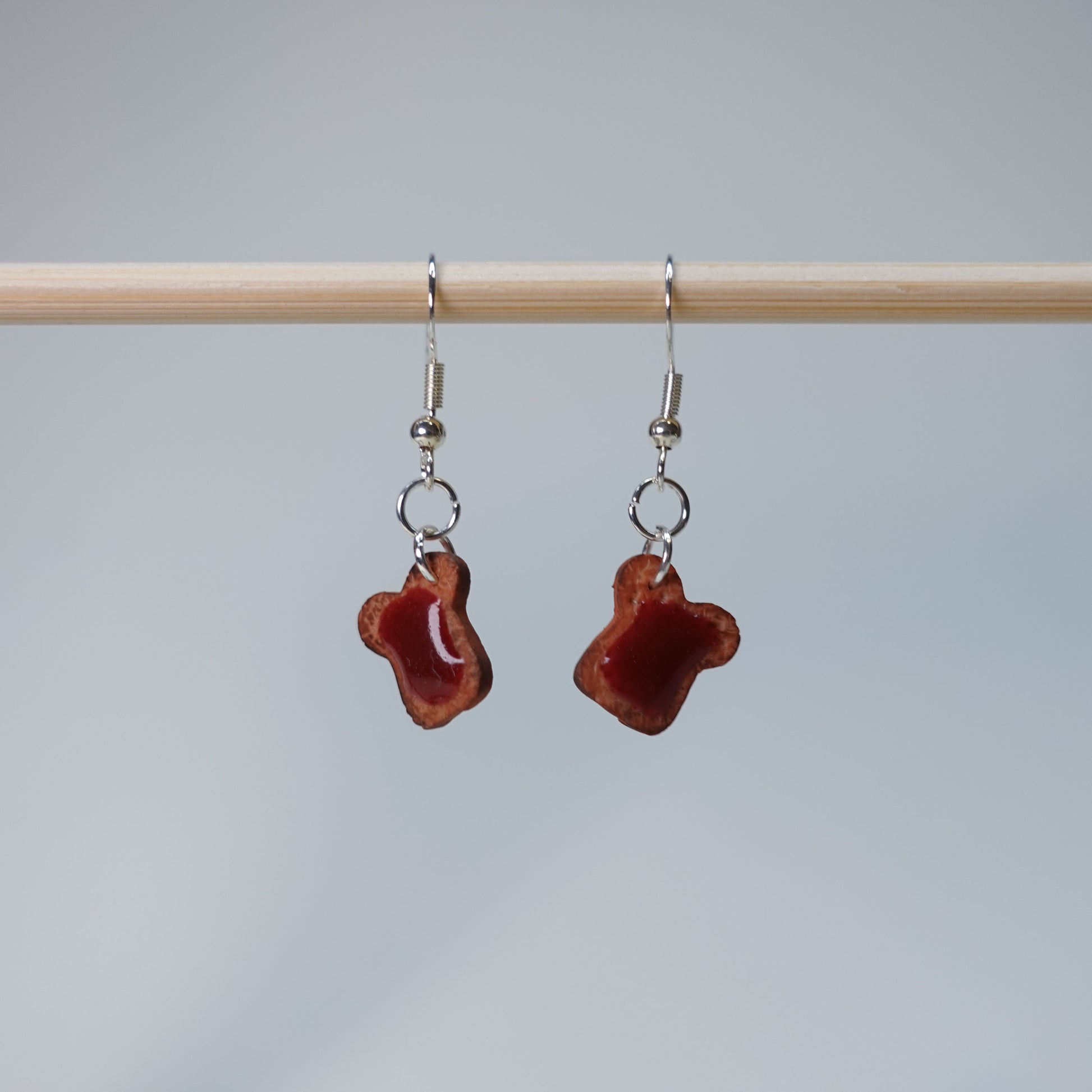 Handmade Toast with Jam earrings set featuring five unique pairs: slightly burned toast, blueberry jam, and strawberry jam, pastel food-themed accessory, 5 pairs available.