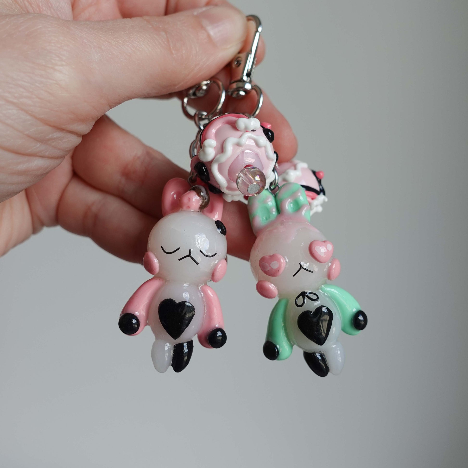 Pair of bunny-shaped keychains in soft pastel shades with magnetic bellies that 'click' together, symbolizing the connection and love shared with your significant other