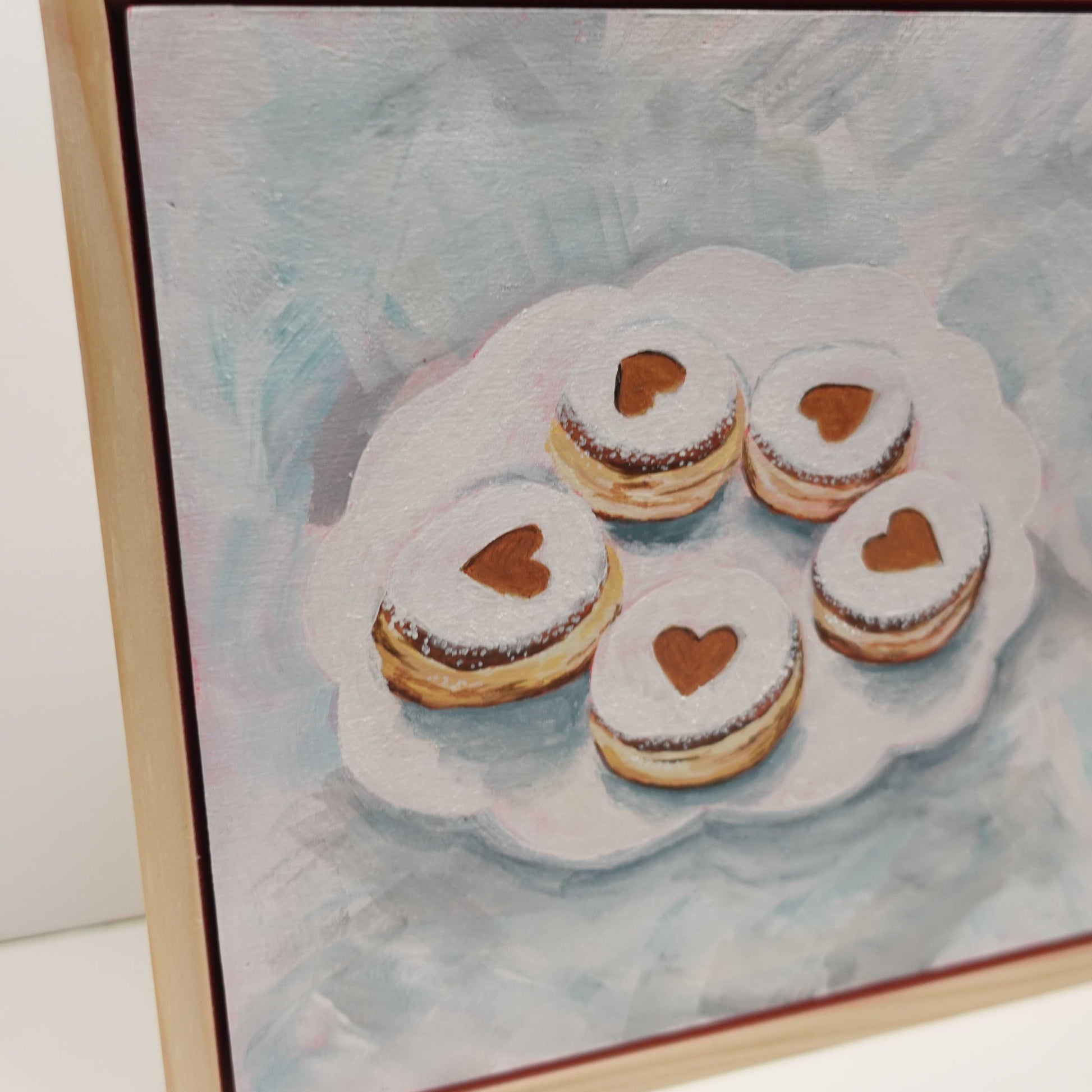 Playful Valentine-themed artwork showing a krapfen in soft tones, acrylic on wood, square format and framed.