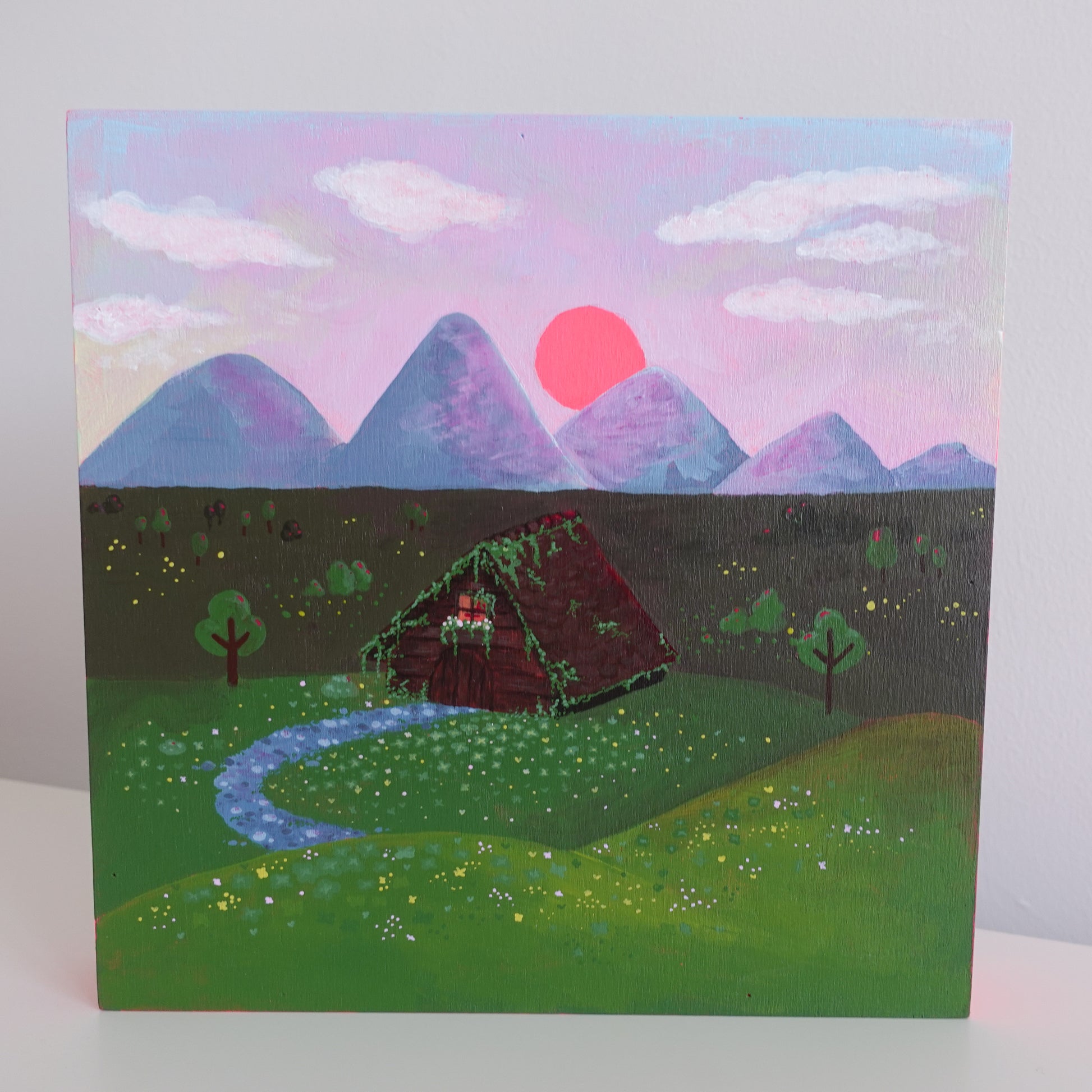 Original painting titled 'Cozy Cottage Ultimate Comfort' by Uncomfy Cherry, depicting a charming cottage surrounded by a lush forest with vibrant colors.